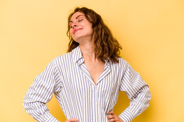 Young caucasian woman isolated on yellow background dreaming of achieving goals and purposes