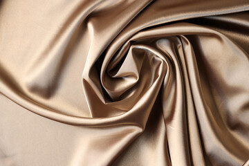 Beige satin fabric background. Texture of viscose is brown background