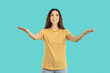Smiling young woman isolated on blue studio background stand with open arms for hug or embrace. Happy female stretch hands to camera. Warm welcome or kindness concept.