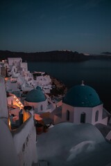 Canvas Print - Vertical drone view of Santorini (Thira) with churches in the foreground at sunset, Greece