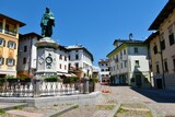 Fototapeta  - Pieve di Cadore, Italy - June 19 2022: Central Tiziano square in the town of Pieve di Cadore in Veneto region and Belluno province in Italy with an old statue