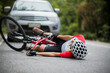© VStudio - An Asian mountain biker was hit by a car on the road. A mountain biker was injured in a collision with a car on the road. Concept reduces accidents from using cars on the road. Selective focus.