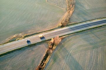 Canvas Print - Aerial view of intercity road with fast driving cars at sunset. Top view from drone of highway traffic in evening