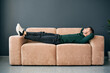 © GVS - Young trendy man relaxing alone on textile sofa at home