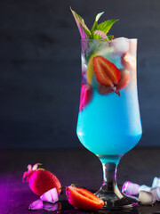 Wall Mural - blue cocktail with strawberries, dark blue background