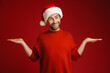 © Drobot Dean - Young smiling man wearing santa hat holding copyspace