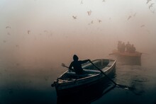 Back View Of A Man Rowing A Boat On The River In Foggy Weather