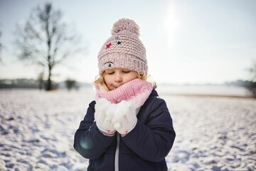 Wall Mural - Cheerful Caucasian baby girl with blonde hair in a park on a sunny winter day