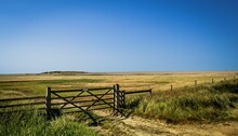 Wooden Fence In A Green Field Under A Clear Cloudless Sky