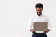 © Drobot Dean - Black bearded man wearing shirt smiling and working with laptop