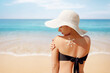 Beautiful Girl on a beach.Sun Protection.Sun Cream. Skin and Body. Woman apply sun cream protection cream on her shoulder.