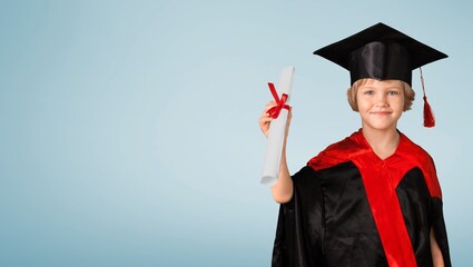 Canvas Print - Cute kid wearing graduation cap and ceremony robe with certificate diploma. Graduate celebrating graduation. Education Concept. Successful elementary school