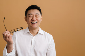 Wall Mural - Brunette adult asian man wearing shirt laughing at camera