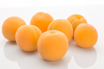 Yellow ripe apricots on a white background