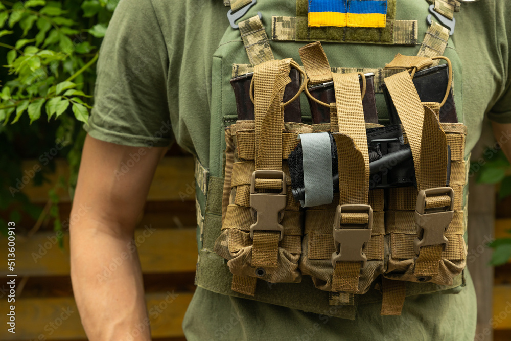 A soldier in a camouflage tactical uniform and a military body armor on ...