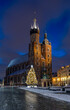 St Mary's church on snow covered Main Square in winter Krakow, illuminated in the night.