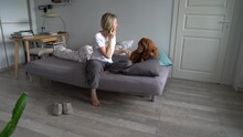 Middle-aged Scandinavian Woman Living Entirely Alone Talking On Phone While Petting Her Wirehaired Vizsla Dog, Mature Female Spending Time With Domestic Animal At Home. Pet Ownership For Single Adults