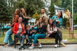 © Minet - Portrait photo of a group of young people having fun while sitting in a park. Selective focus. High quality photo