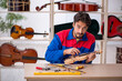 © Elnur - Young man repairing musical instruments at workshop