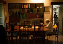 Old Woman Sitting On Dining Table Alone 