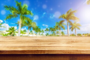 Canvas Print - Top of wood table with seascape and palm tree, tropical beach background. summer vacation background concept.