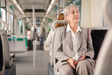 European Senior Woman Sitting On Her Seat In Tram And Waiting For Next Stop.