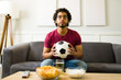 © AntonioDiaz - Latin young man looking worried while watching a soccer game on tv