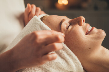 Wall Mural - close-up portrait of a woman getting face massage in spa salon. doctor hands. pretty female patient.