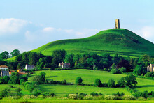 Ruined Church Tower Tops The Ancient Pagan Mystical Hill Of Glastonbury Tor Above The Village Of Glastonbury, Somerset, England.