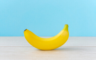 A banana on the table.  light blue background.  テーブルの上のバナナ。　水色背景