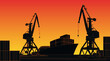 © Vladimir Kazakov - Silhouette commercial port with container ship at the pier and cargo cranes on background with sunset sky.
