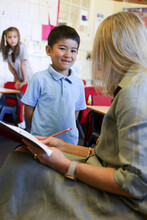 A Boy In School Uniform Talking To His Teacher