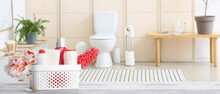Set Of Cleaning Supplies And Spring Flowers On Table In Bathroom