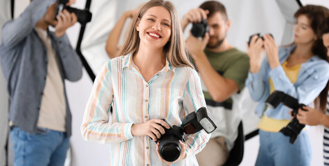 Poster - Portrait of pretty female photographer in studio