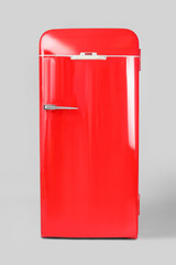 Stylish retro fridge on light background