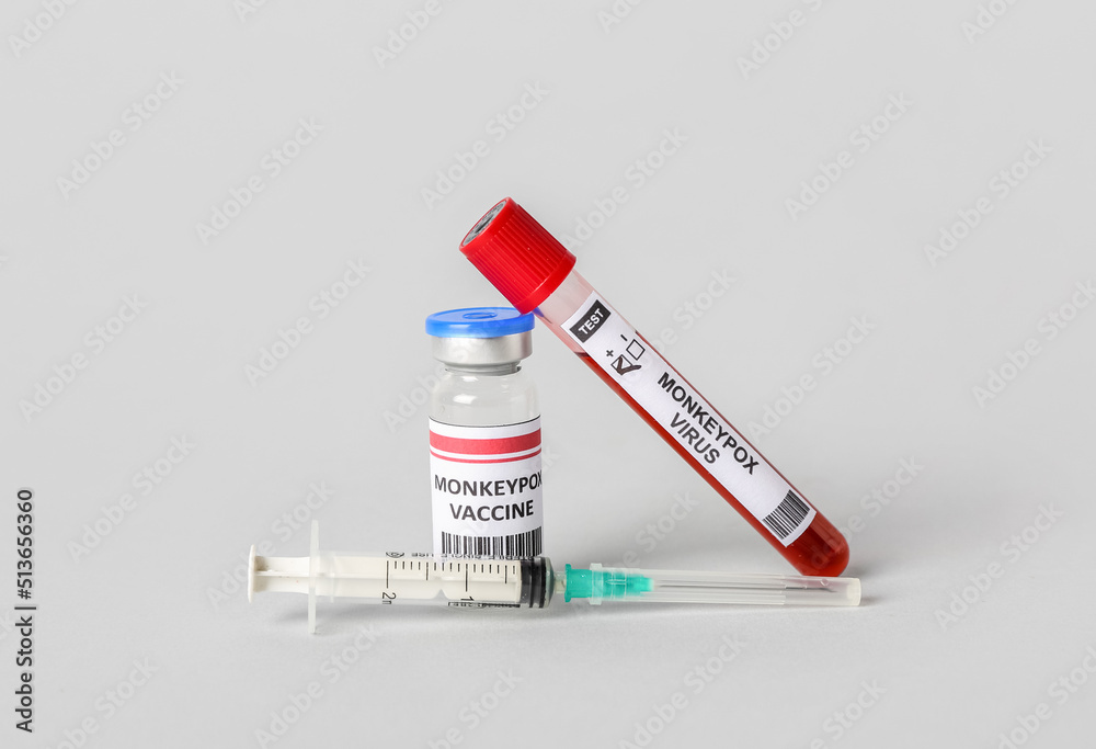 Monkeypox vaccine with blood sample and syringe on grey background
