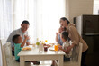 © DragonImages - Happy joyful Asian family of five eating tasty breakfast at kitchen table