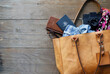© Austockphoto - Tan leather tote bag with travel items on wooden floorboards