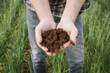 © Austockphoto - Farmer holding soil in a cereal crop in the Wheatbelt of Western Australia