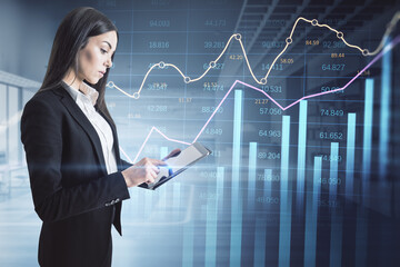 Poster - businesswoman using tablet with abstract glowing business chart with index and growth on blurry office interior background. Finance, trade and market report concept. Double exposure.