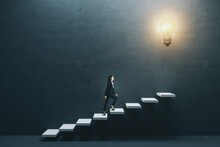 Way To Success And Creative Idea Concept With Young Woman Climbing White Stairs To Big Illuminated Light Bulb On Dark Grey Wall