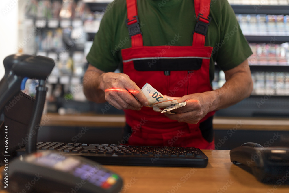 Employee taking cash payment from costumer in gas station, close-up ...