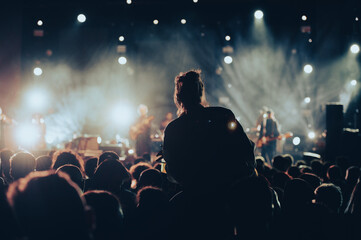 Wall Mural - Silhouette of a woman with raised hands on a concert