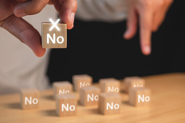 Evaluation and decision concept. Rejection or No or False symbols. Man holds a wood block with copy space.