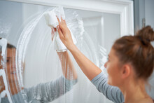 Picture Of Yound Woman Cleaning Mirror Window