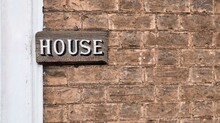 Brown Brick Wall Background With Inscription House Copy Space. High Quality Photo