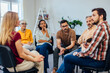 © bnenin - People sitting in the circle talking to each other about their mental health.