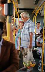 Poster - Grandfather and granddaughter  with groceries in city bus