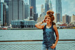 © Carlos David - Portrait beautiful young adult woman afro hairstyle with Manhattan New York City skyline in the background outdoors looking at camera shot