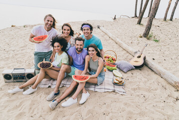 Sticker - Photo of positive sweet young people wear casual clothes sitting beach eating berries outside countryside